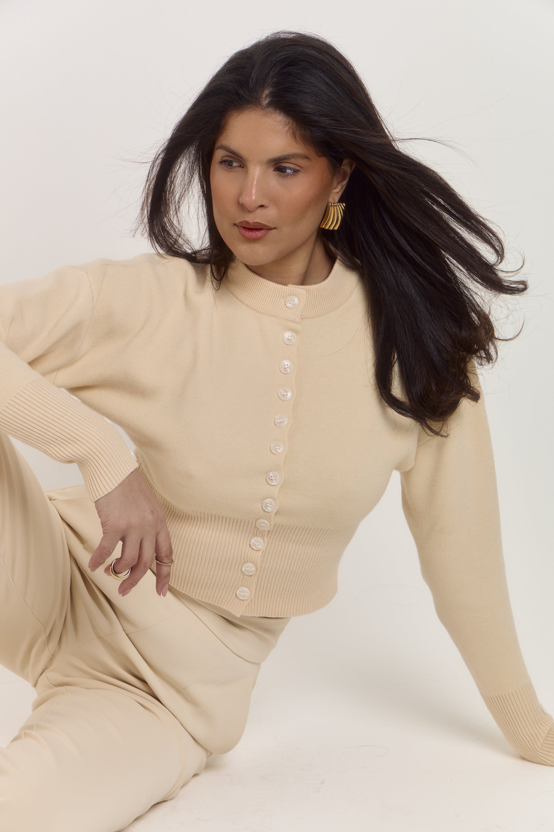 Cream shaping cardigan designed to flatter the waist and frame the neckline.