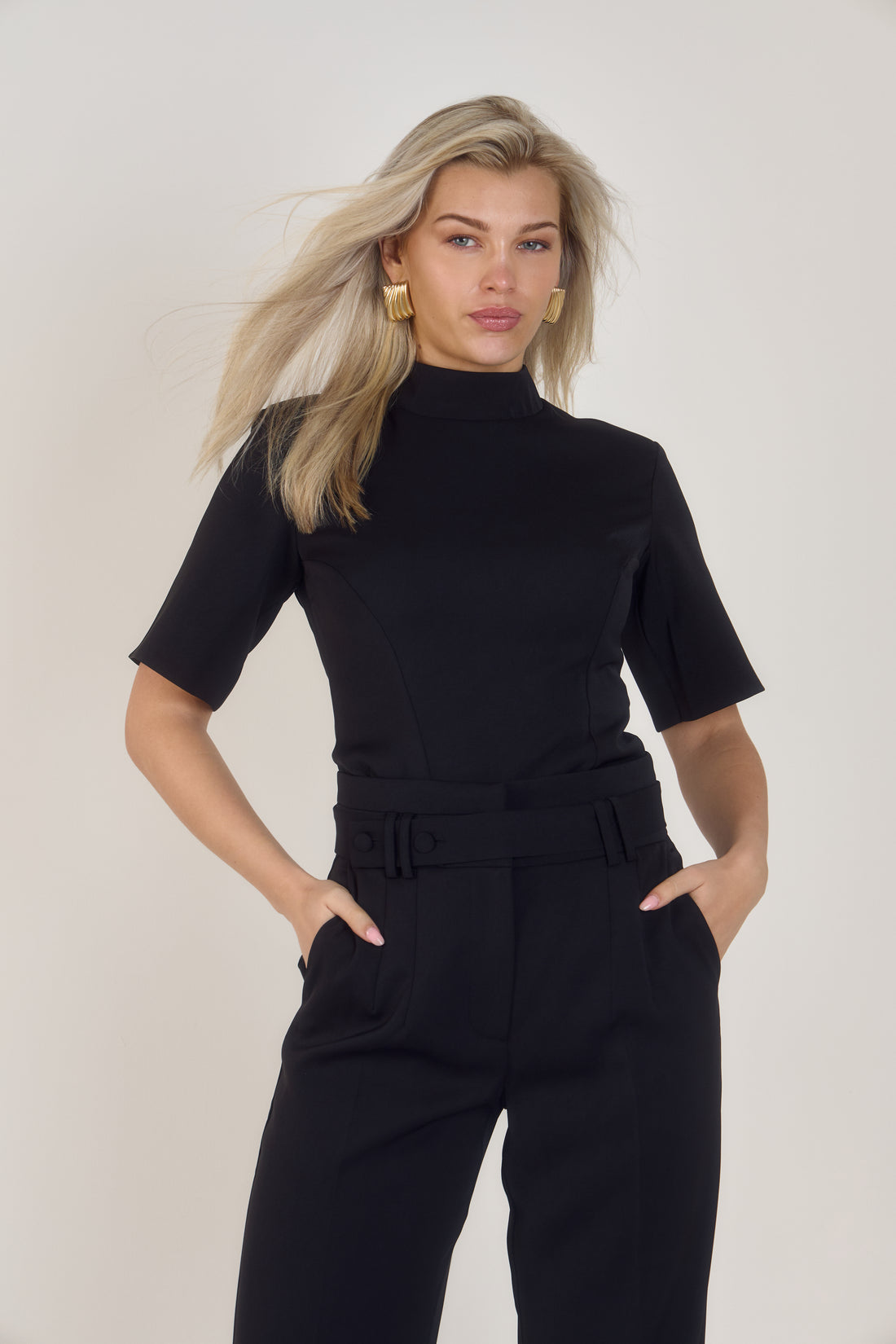 Front view of Ardore London’s Tailoring Sculpted High Neck Top in Classic Noire, featuring a flattering cinched fit, wide sleeves, and premium soft fabric