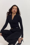 Premium black cotton rib long sleeve bodysuit with refined minimal aesthetic.