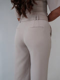 Back view close-up of tailoring wide leg trousers in chai latté by Ardore London, showcasing the clean lines and fabric details without the belt.
