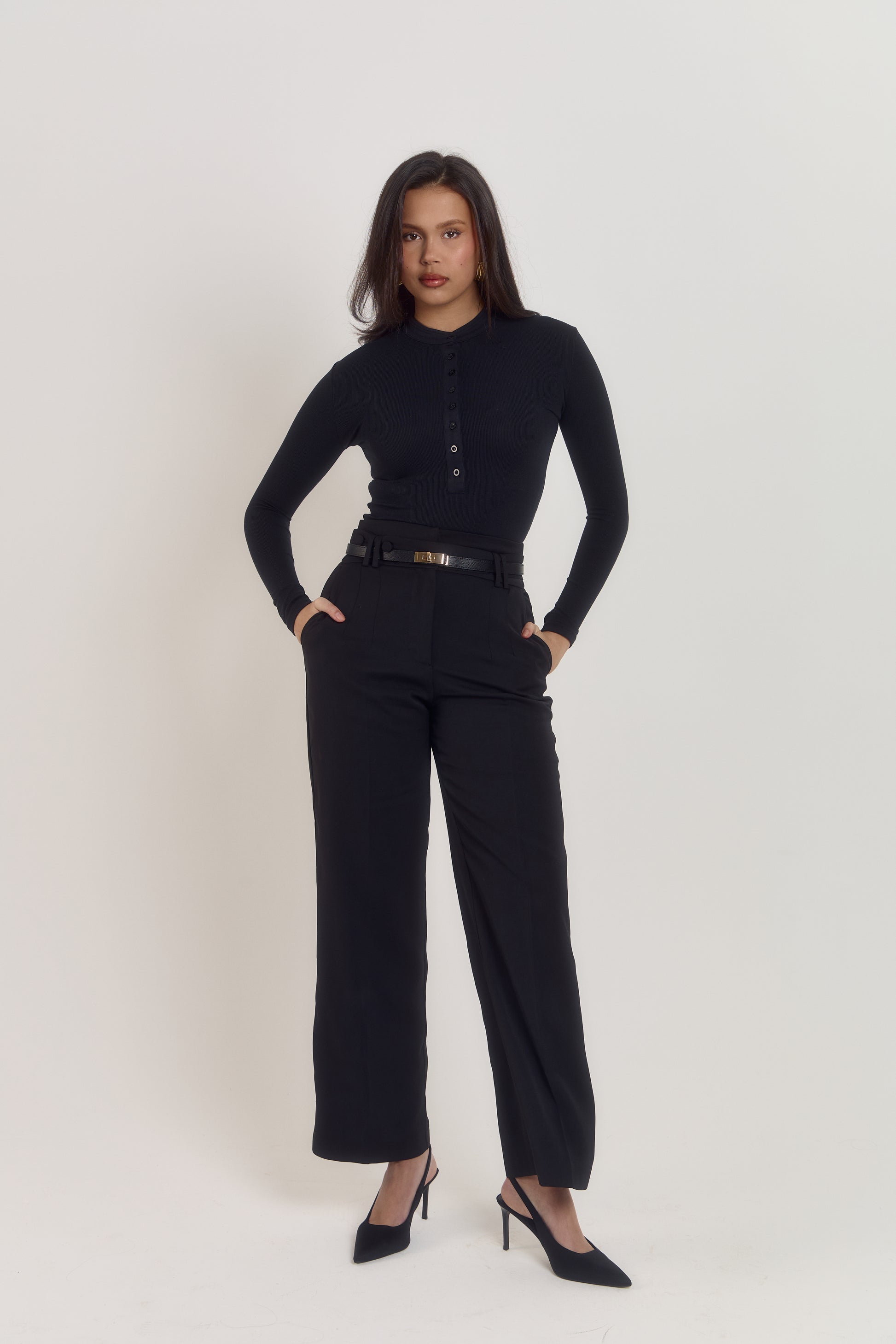 Black cotton ribbed long sleeve bodysuit with pearlised button front and fitted silhouette.