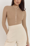 Model wearing tan cotton rib Henley bodysuit with long sleeves and second-skin fit.