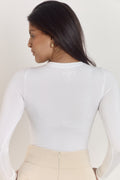 Smoothing white contour bodysuit styled under tailored trousers.