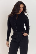 Mid-length black sculpting waist cardigan with elegant movement and triple button cuff feature.