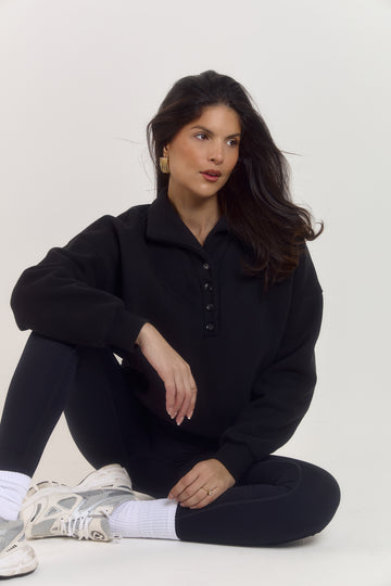 Oversized black cotton knit sweater with collared neckline, tortoiseshell buttons and cosy structured fit.