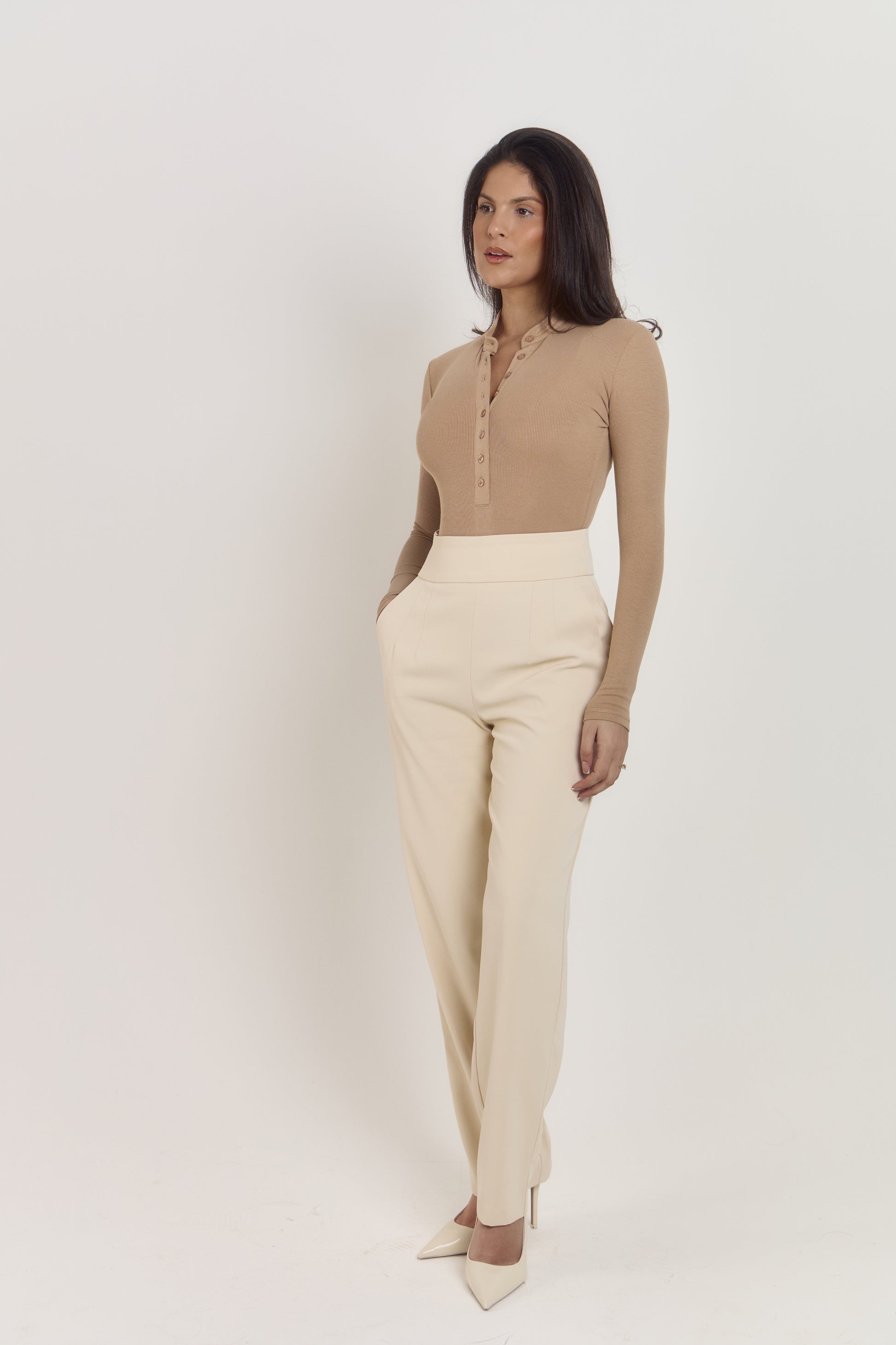 Neutral tan long sleeve cotton bodysuit with classic Henley neckline.
