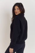 Close-up detail of black cotton oversized collared sweater with quarter button closure and premium structured fabric.