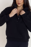 Model styled in oversized heavyweight cotton black sweater with structured collar worn folded down.