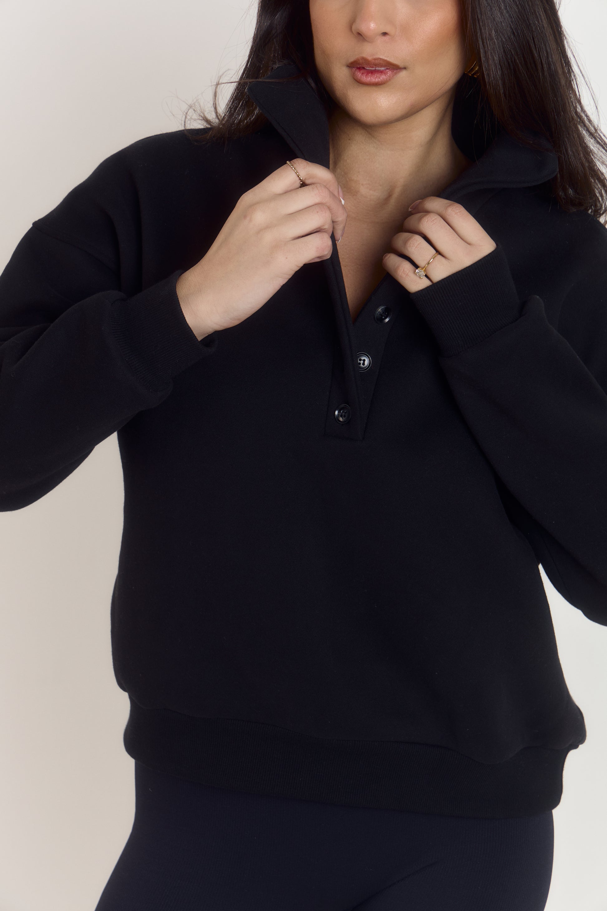 Model styled in oversized heavyweight cotton black sweater with structured collar worn folded down.