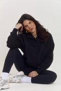 Premium oversized black cotton sweater with structured collar and quarter button front for elevated everyday wear.