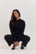 Elegant black long sleeve cardigan with sculpted waist, tapered sleeves and refined rounded neckline.