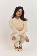 Cream cardigan featuring tonal statement buttons and a sculpting tailored fit.