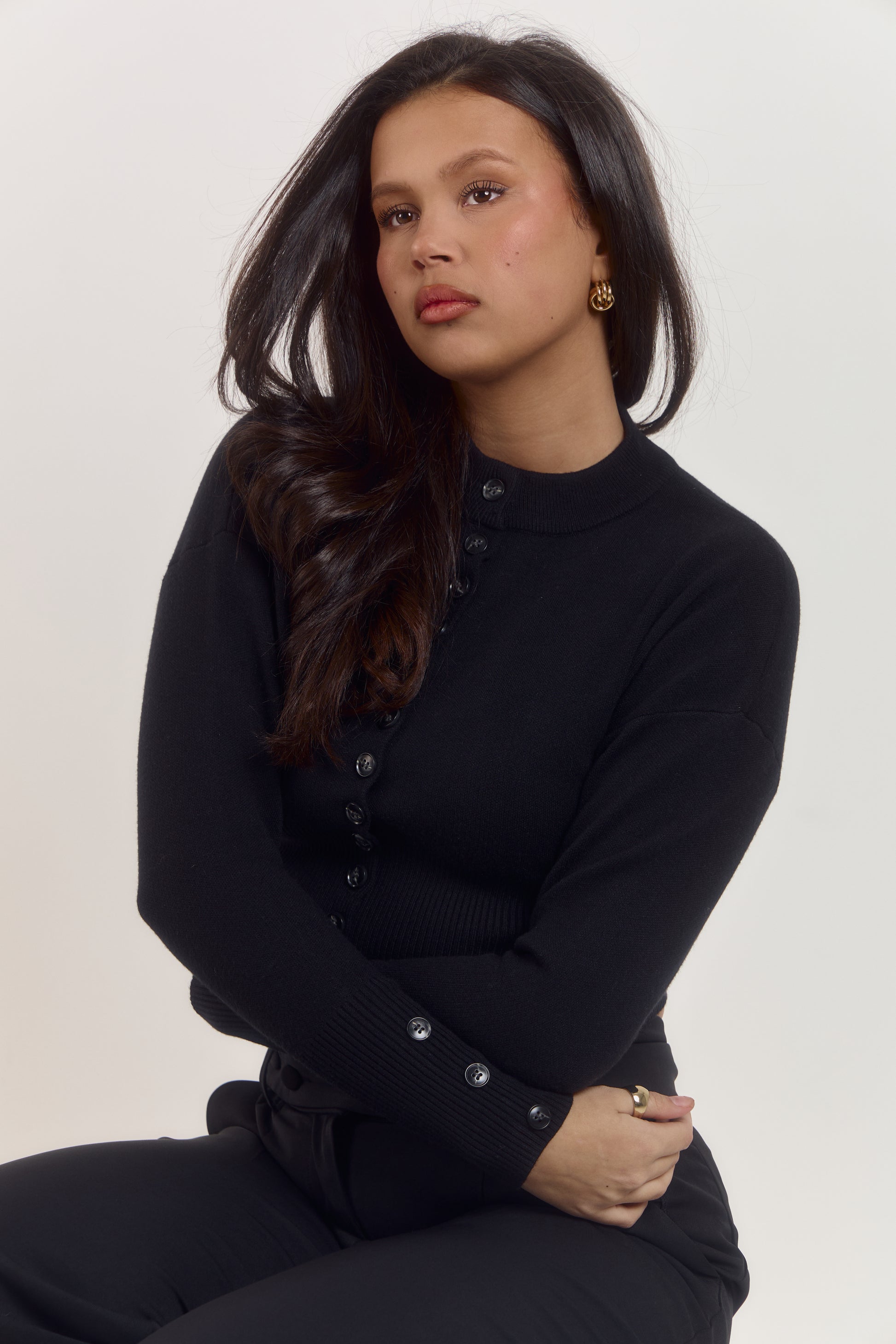 Luxury black long sleeve cardigan designed to contour the waist and create a tailored silhouette.