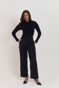 Model wearing structured long sleeve black sculpting waist cardigan with statement buttons and fitted tailored silhouette.