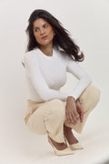 Long sleeve white smoothing bodysuit with adjustable popper fastening.
