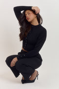 Women’s fitted black knit cardigan with waist defining shape and functional button front closure.