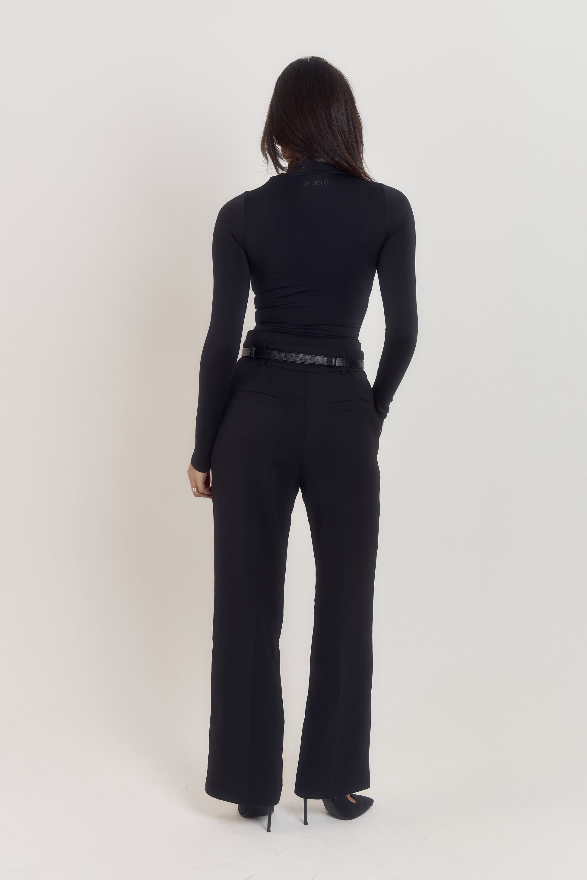 Long sleeve compression bodysuit in black with body contouring structure.