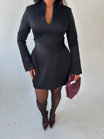 Close-up of Ardore London black satin split sleeve mini dress, featuring a pleated V-shaped waist for a flattering fit, an elegant A-line skirt, and fluid split sleeves—crafted in lustrous satin for a sleek winter-ready silhouette with graceful movement and modern edge.