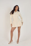 Ardore London Vanilla Crème structured long sleeve pleated mini dress, featuring precise tailoring, a textured fabric, and defined sleeve construction—an elegant, cozy choice for winter with its warm tones and full coverage silhouette.