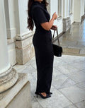 Side view of Ardore London Sculpting Short Sleeve Buttoned Maxi Dress in Classic Noire, showcasing the sleek silhouette, flattering curved seams, and statement collar for a timeless, polished look.