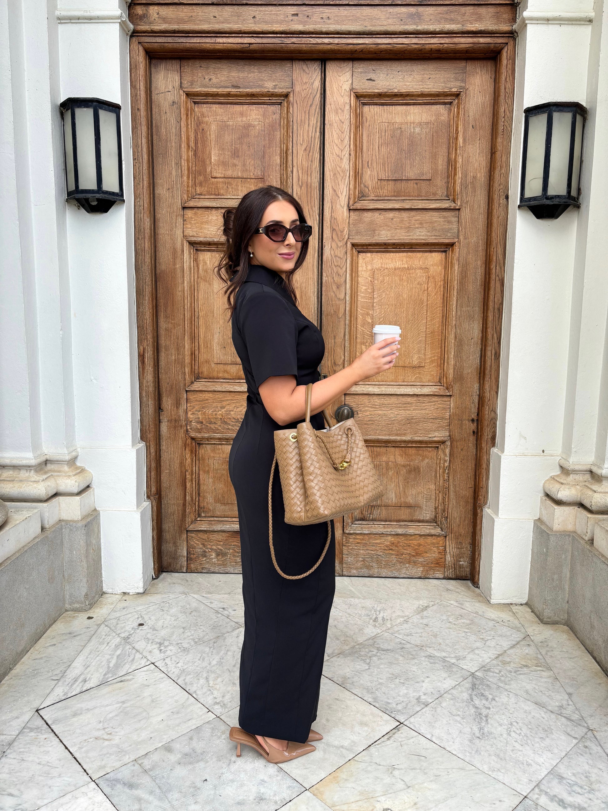 Side view of Ardore London Sculpting Short Sleeve Buttoned Maxi Dress in Classic Noire, styled for a chic office look. Featuring a flattering silhouette, structured collar, and elegant curved seams, this dress exudes sophisticated professionalism.