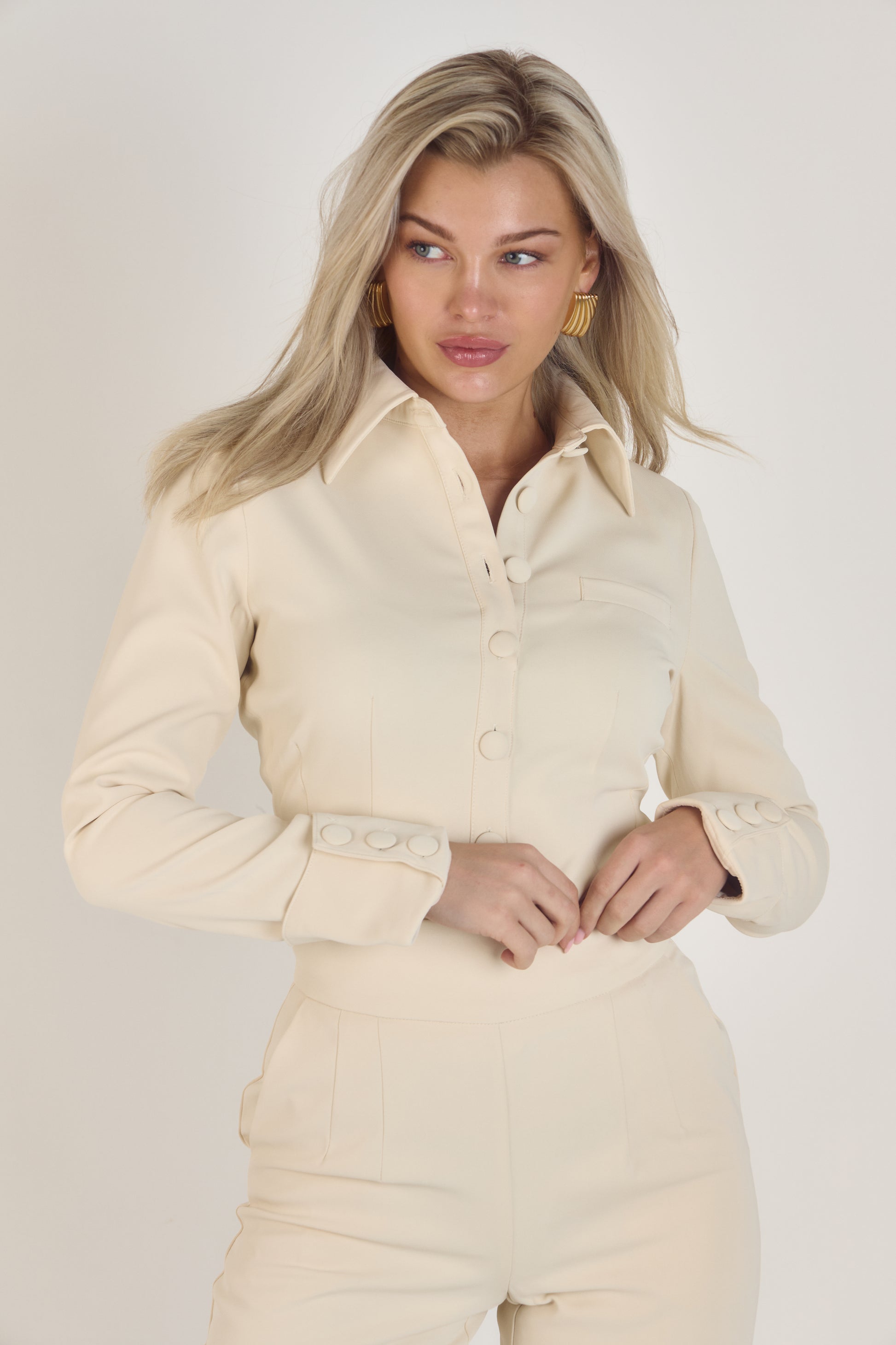 Ardore London Vanilla Crème structured long sleeve sculpted blouse paired with cream trousers, featuring sculpted tailoring, signature triple-button cuffs, exaggerated collar, and soft, luxurious fabric for an elevated, chic look.