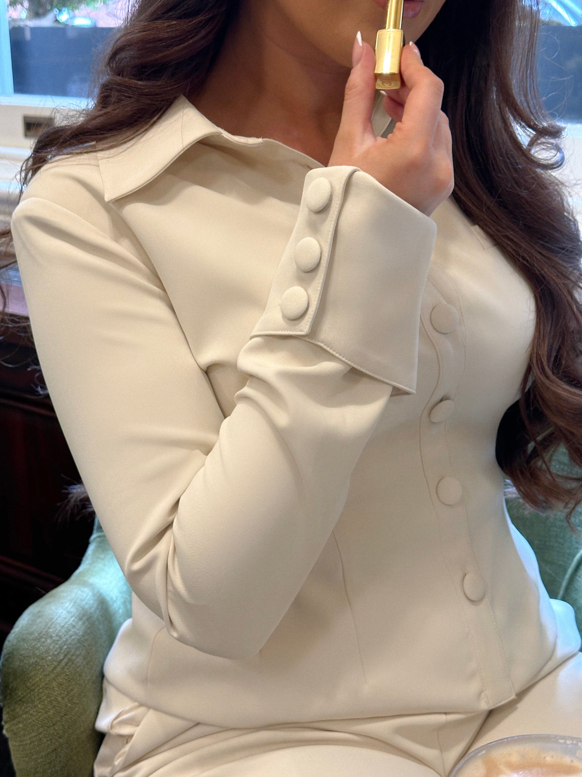 Close-up of Ardore London Vanilla Crème structured long sleeve sculpted blouse, highlighting the luxurious fabric, sculpted fit, and signature triple-button cuffs with exaggerated collar for a chic, 1970s-inspired look.