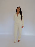 Front view of Ardore London Vanilla Crème structured long sleeve sculpted blouse paired with cream trousers, highlighting sculpted tailoring, signature triple-button cuffs, and an exaggerated collar for a clean, chic, and polished look.