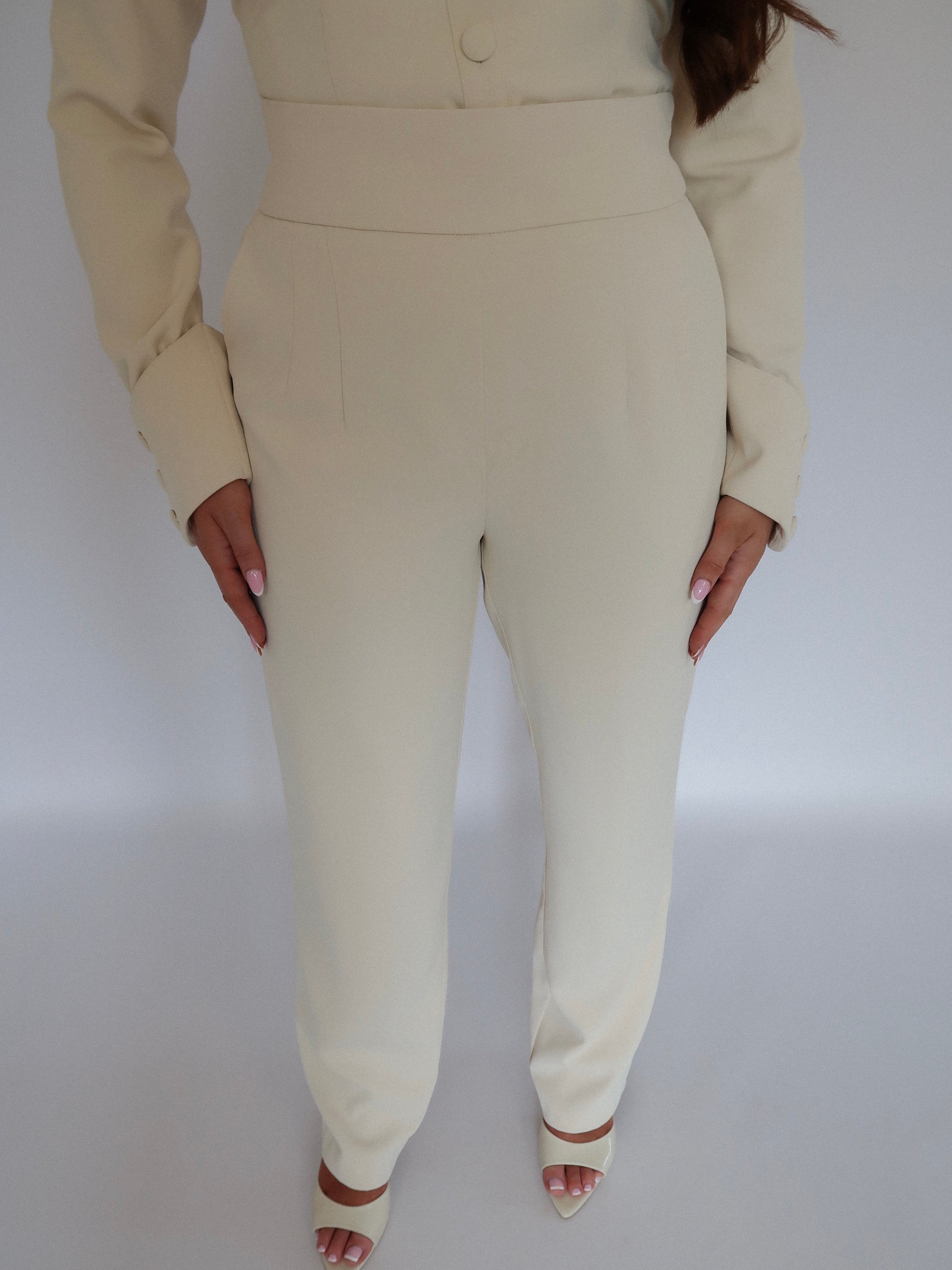Front close-up of Ardore London Vanilla Crème high-waisted straight leg trousers, highlighting the sculpted fit, cinched high waist, and functional side pockets for a flattering, polished silhouette.