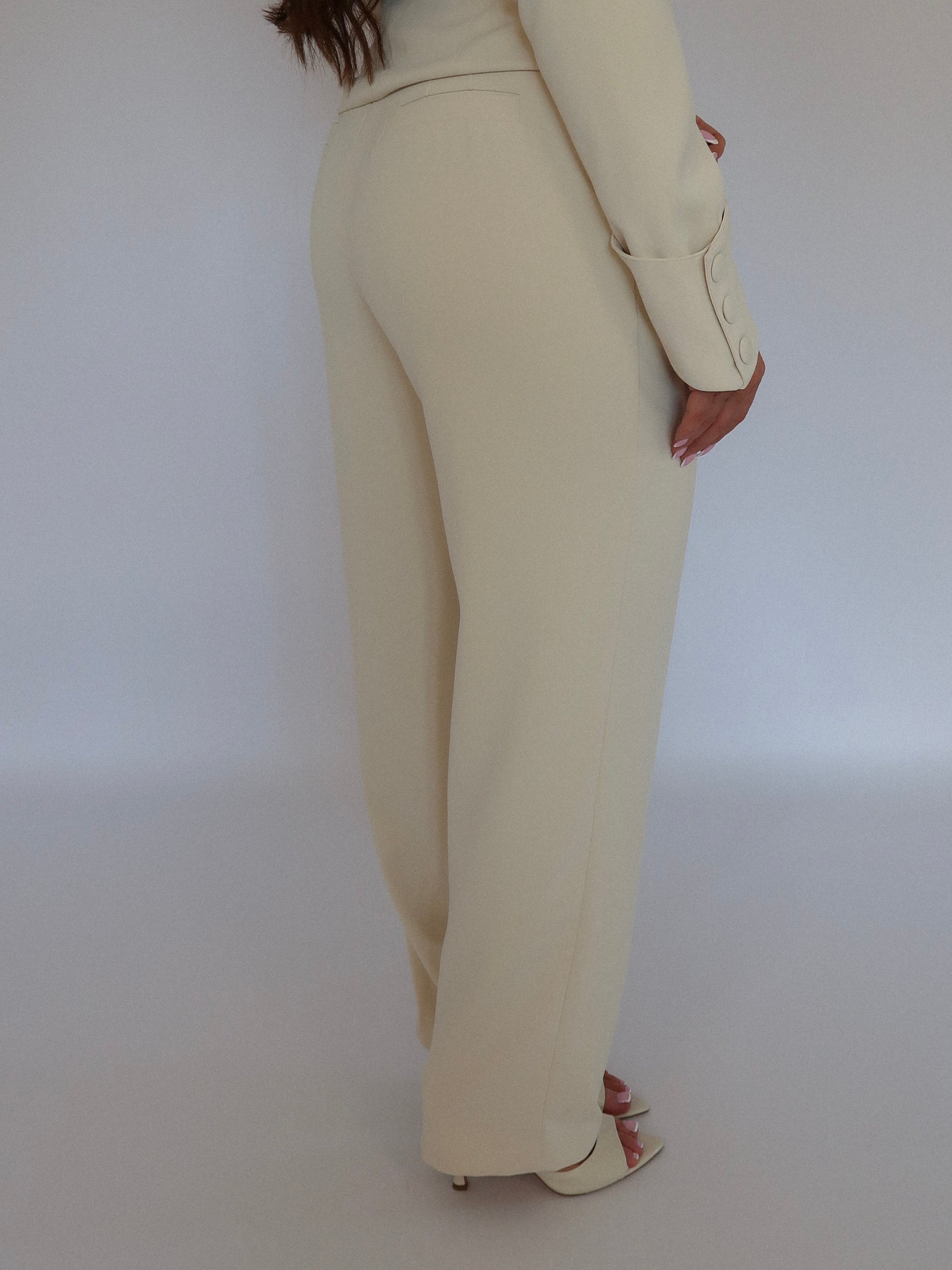 Side view of Ardore London Vanilla Crème high-waisted straight leg trousers, showcasing the sculpted silhouette, flattering high waist, and smooth, tailored fit for a chic and polished look.