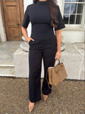 Front view of Ardore London’s Tailoring Sculpted High Neck Top in Classic Noire, featuring a flattering cinched fit, wide sleeves, and premium soft fabric