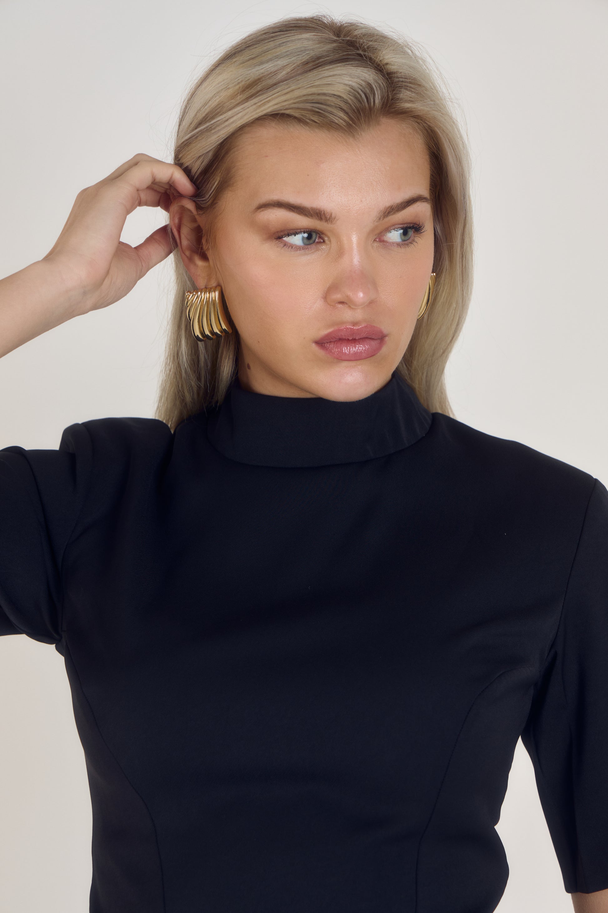 Front view of Ardore London’s Tailoring Sculpted High Neck Top in Classic Noire, featuring a flattering cinched fit, wide sleeves, and premium soft fabric
