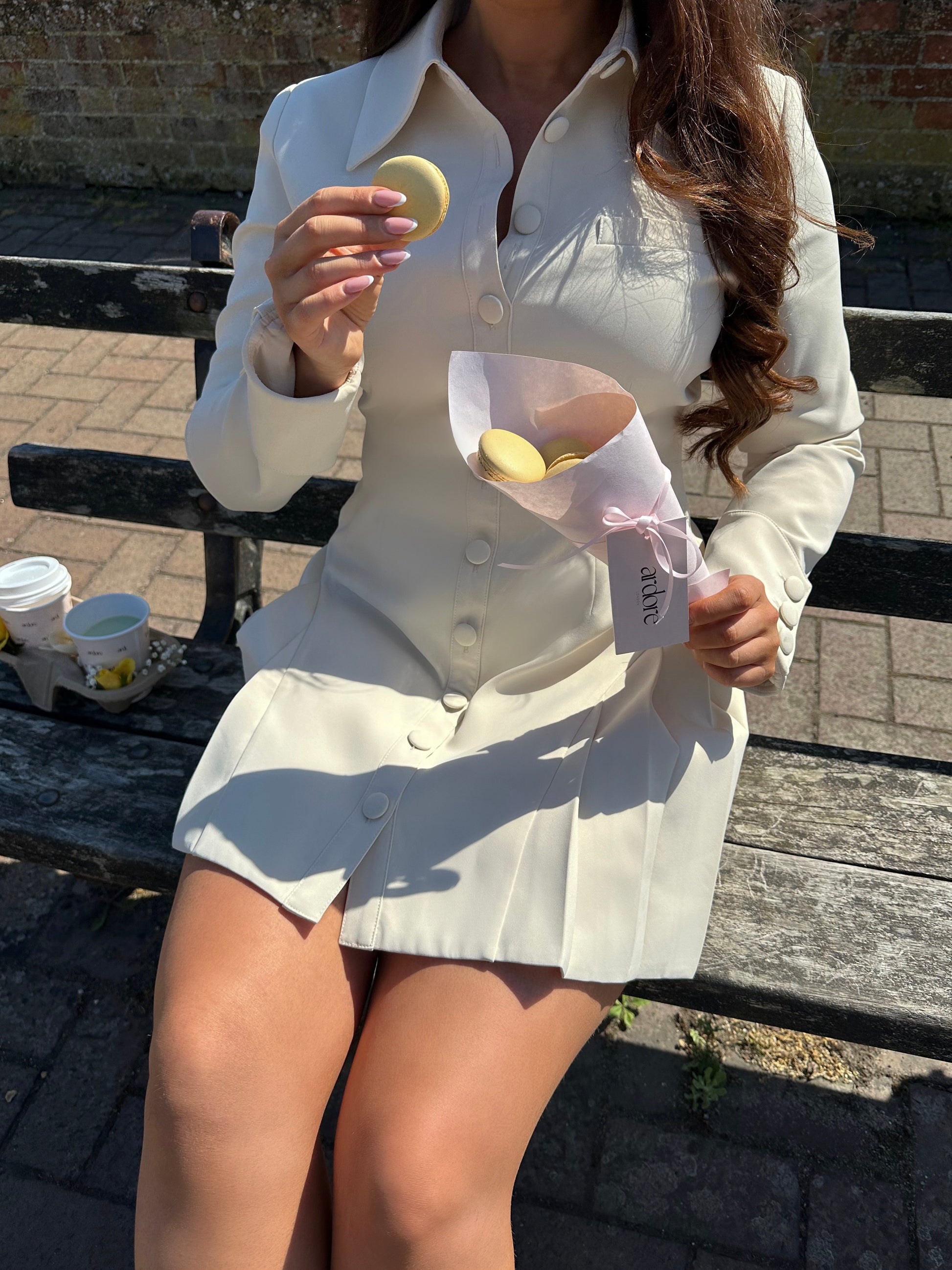 Close-up shot of structured Vanilla Crème long sleeve pleated mini dress by Ardore London highlighting expert tailoring and delicate fabric pleats.