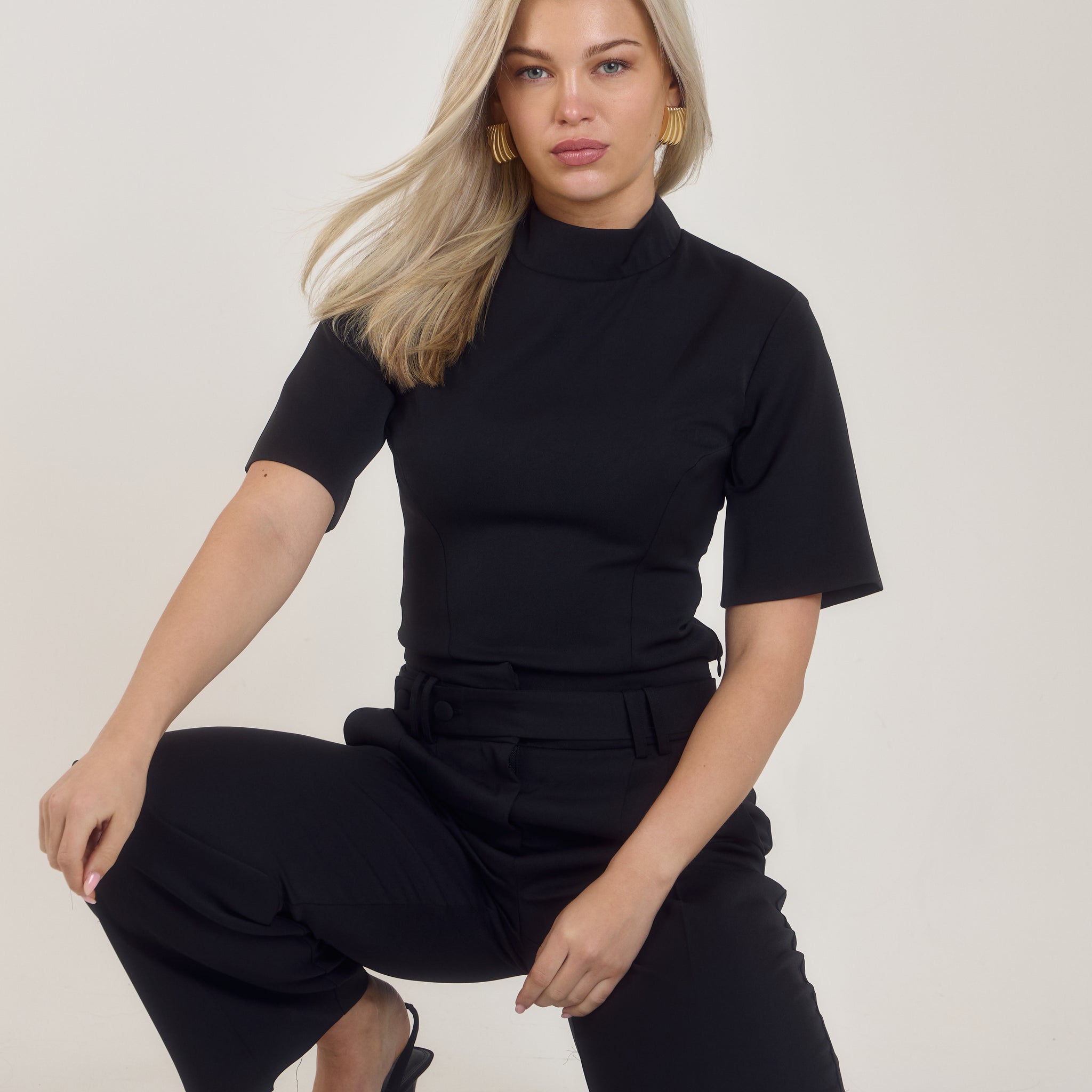 Front view of Ardore London’s Tailoring Sculpted High Neck Top in Classic Noire, featuring a flattering cinched fit, wide sleeves, and premium soft fabric